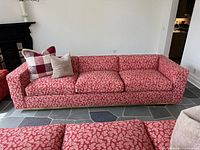 Front view of red floral sofa with accent pillows