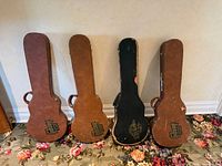 Front view of four Gibson guitar cases standing upright