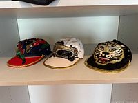 All three Harpurs embellished caps on shelf
