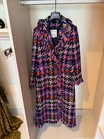 Full view of multicolor tweed coat on hanger