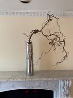 Full view of tall silver bark-textured vase on mantel