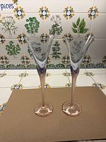 Full view of both champagne flutes front angle showing coloured stems