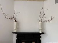 Both matching white ceramic vases on mantel