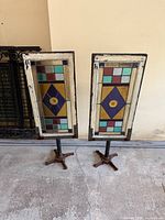 Two stained glass panels on iron stands, front view
