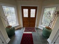 Both celadon floor vases flanking entry doors showing scale and condition