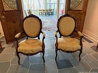Front view of matching carved walnut armchairs