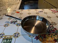 Top view of 12" stainless fry pan on tiled counter