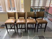 Front view of four matching leather barstools