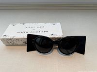 Front view of black Gyrolite sunglasses and branded box