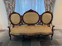 Front view of Victorian-style walnut settee showing full frame and upholstery