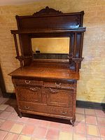 Front view of Victorian tiger oak sideboard showing mirror, drawers, cabinet doors, and grain pattern