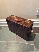 Front and top view of closed attache showing faux alligator exterior and handle