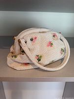 Front view of Lumured beaded handbag showing floral beadwork and handles