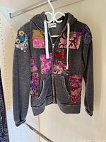Front view of grey hoodie with patchwork