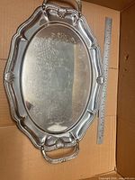 Top view of entire tray showing ornate rim, handles, size reference with ruler