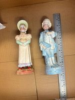 Front view of both figurines with ruler for scale