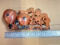 Front view showing carved vases, flowers and scale