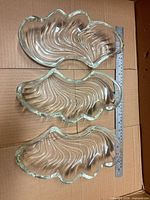 Three clear glass swirl dishes beside 45 cm ruler