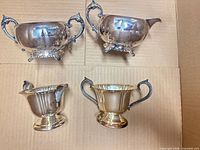 Group shot of four silver-plated serveware pieces