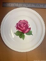 Top view plate with rose motif, ruler shows scale