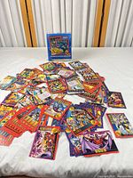 Pile of assorted Marvel X-Men Series II trading cards spread on table with display box behind