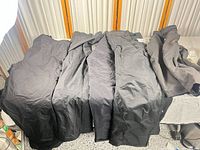 Five black pants laid out side-by-side