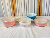 Front view of four lidded casseroles and blue mixing bowl