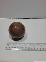 Sphere beside ruler showing diameter ~2.5 inches