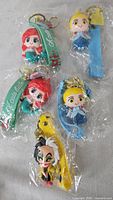 Overview of four packaged Disney keychains showing characters and straps