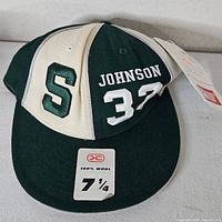 Front view of fitted cap showing S logo, Johnson 32 embroidery, size sticker and hang tags