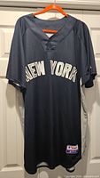 Front full view of navy Majestic Yankees jersey on hanger