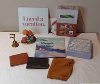 Overview of all items laid out: two signs, figurine, brass bell, three wallets, boxed unicorn sign