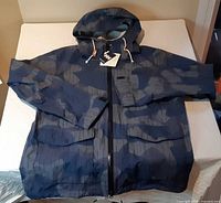Front view of Helly Hansen blue camouflage hooded jacket with tags attached