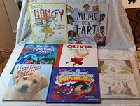 Nine children’s books laid out on white cloth