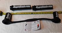 Elastic band, two support pipes, tape measure showing length, instruction sheet visible