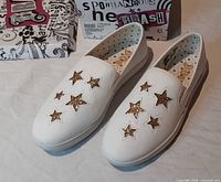 Top and side view of both shoes showing gold star cutouts and box