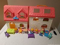 Folded-open dollhouse with figures and furniture arrayed in front