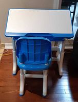Front view of blue and white kids adjustable desk with matching chair