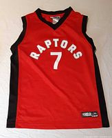 Front view of red Raptors jersey showing number 7 and NBA hem tag
