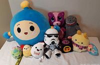 Group shot of all visible plush toys with measuring tape for scale