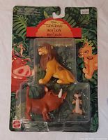 Front view of sealed blister pack showing three figures and card graphics