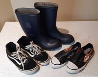 Group shot of three pairs: Kamik boots, Vans sneakers, Ed Hardy slip-ons