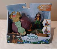 Front of open retail package showing Raya figure, Tuk Tuk with shell and product graphics