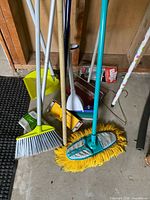 Cluster of cleaning tools: broom, dust mop, dustpan, squeegee, hangers