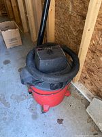 Vacuum showing red canister, motor head, hose wrapped around body
