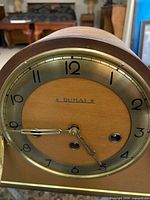 Close-up of Dumal dial showing brass bezel, Arabic numerals and winding arbors