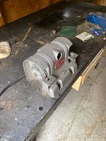 Bench grinder on workbench top with vise partially visible