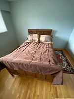 Bed with headboard, footboard, comforter and pillows in place