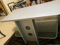 Top view of the stand showing light gray finish and upper glass shelf