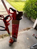 Both corded string trimmers, Craftsman in box and Black+Decker held above